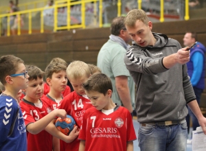 Marcel Bosse, Spieler in der zweiten Herrenmannschaft der Handballfreunde, erklärt dem Nachwuchs eine der sechs Übungen beim Vielseitigkeitsturnier. (Foto: Heidrun Riese)